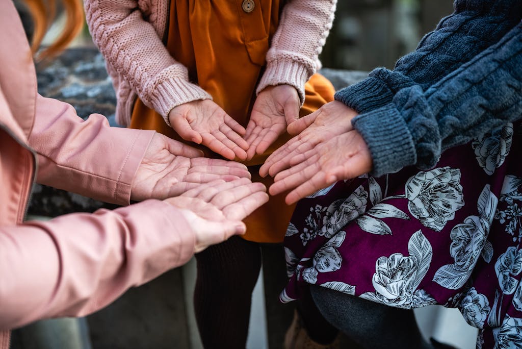 Close-up view of women's hands forming a circle outdoors in Victoria, BC.